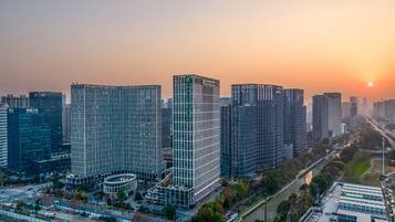 Un complejo de edificios urbanos de gran altura, con varios rascacielos, una torre central con fachada en forma de cuadrícula y zonas verdes circundantes con calles.