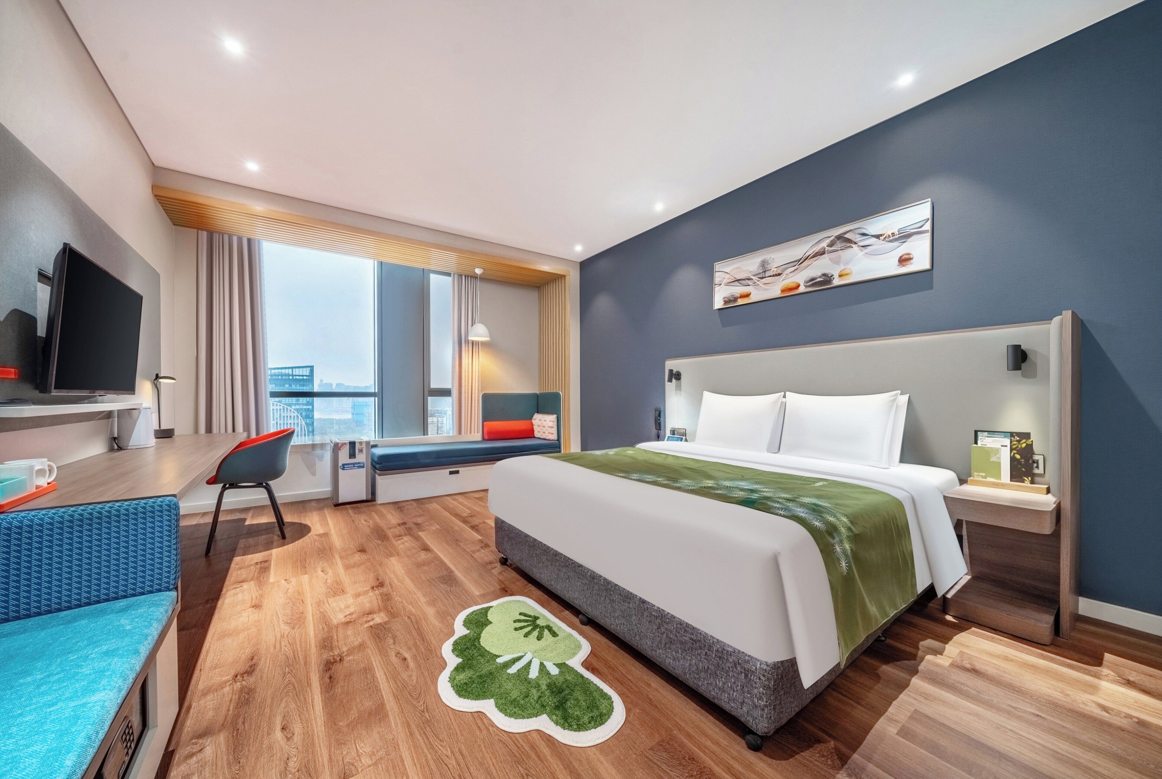 Habitación de hotel moderna con una cama grande, un escritorio con una silla, televisión y ventana con vistas.