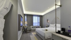 A modern hotel room with a large bed, a desk, a chair, a TV, and a bathroom. - Mercure Taiyuan Jinyang (Taiyuan)