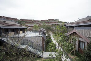 A traditional courtyard with tiered buildings, a central staircase, and a view of the surrounding area.