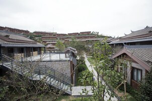 Un patio tradicional con edificios escalonados, una escalera central y vistas del entorno.