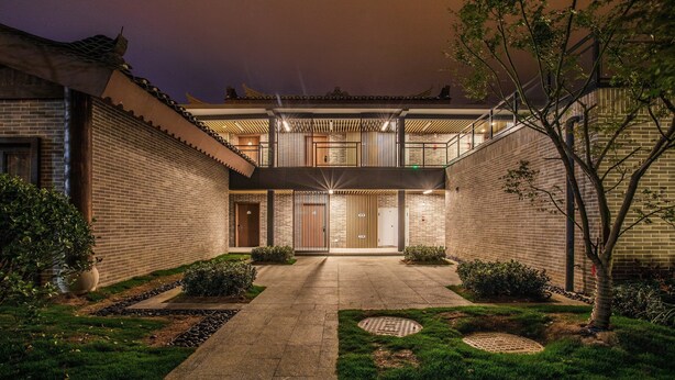 A courtyard with a traditional building, a covered walkway, and a well-maintained garden. - Holiday Inn Express Guizhou Qinglong by IHG (Qianxinan Buyei and Miao)