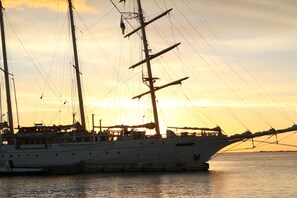 A large sailing ship docked at a harbor during sunset. - Hotel Islander Bonaire (Kralendijk)