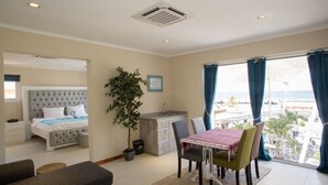 Une chambre d’hôtel équipée d’un lit, d’un bureau, d’une table à manger et offrant une vue sur la ville.