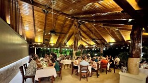 An outdoor dining area with wooden beams and tables. - Hotel Playa Espadilla  (Quepos)