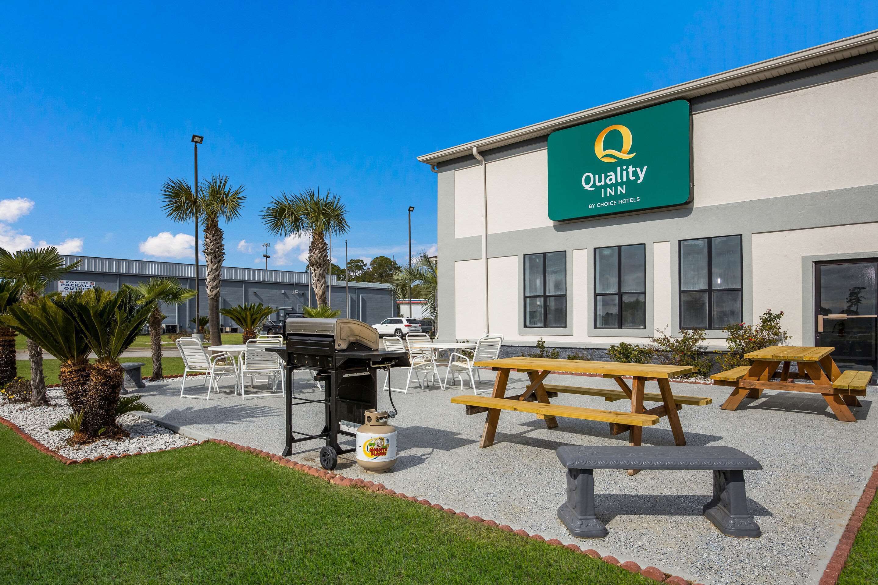 Un hôtel Quality Inn, appartenant au groupe Choice Hotels, doté d’une terrasse, d’un barbecue et offrant une vue sur un ciel bleu dégagé.