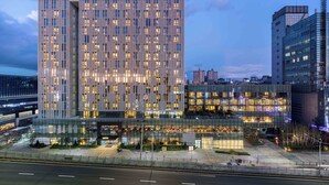 Un hotel moderno con fachada de vidrio, varios pisos y un llamativo letrero de 'ANDAZ'.