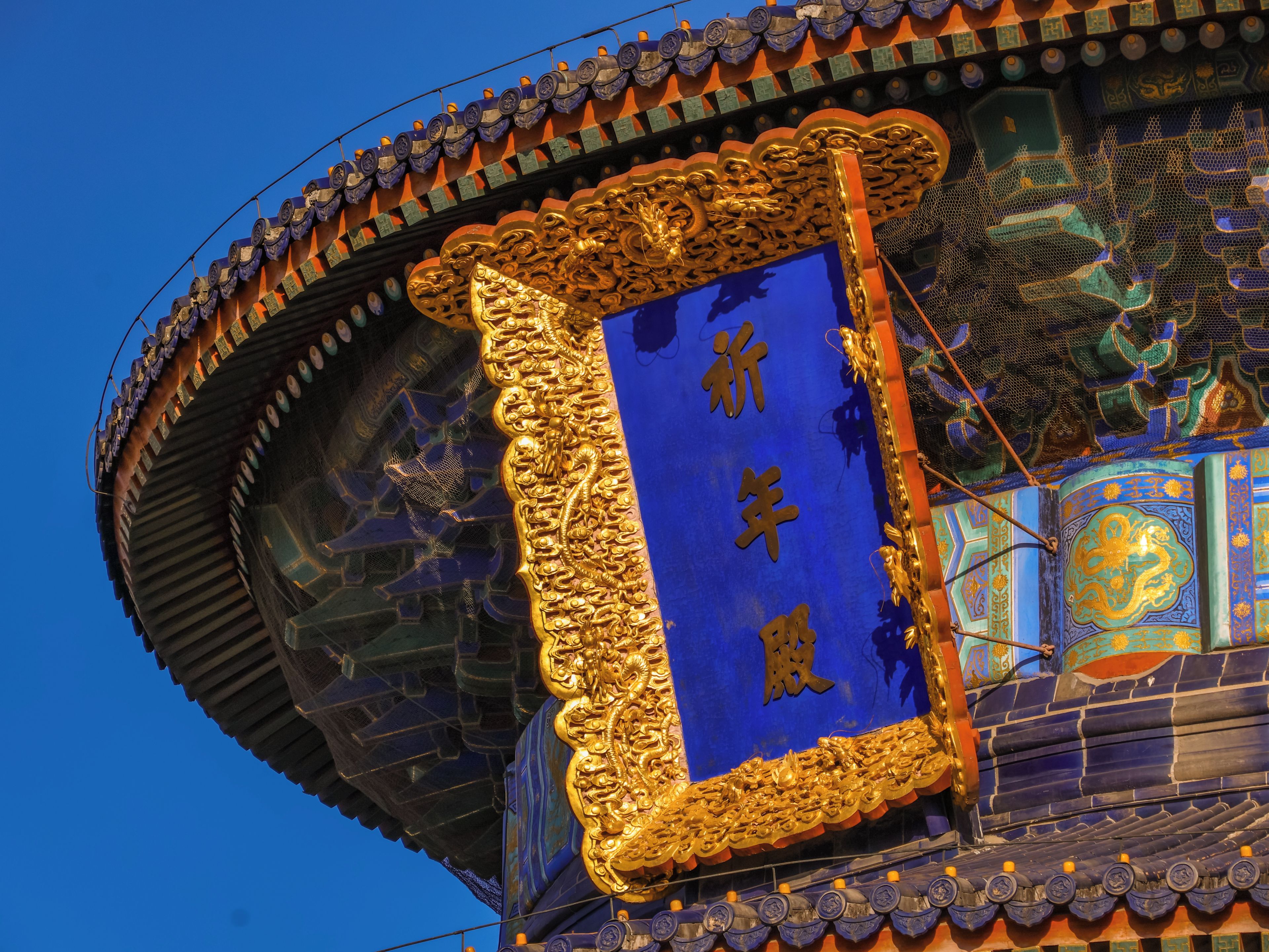 A traditional building with ornate golden decorations and blue panels.