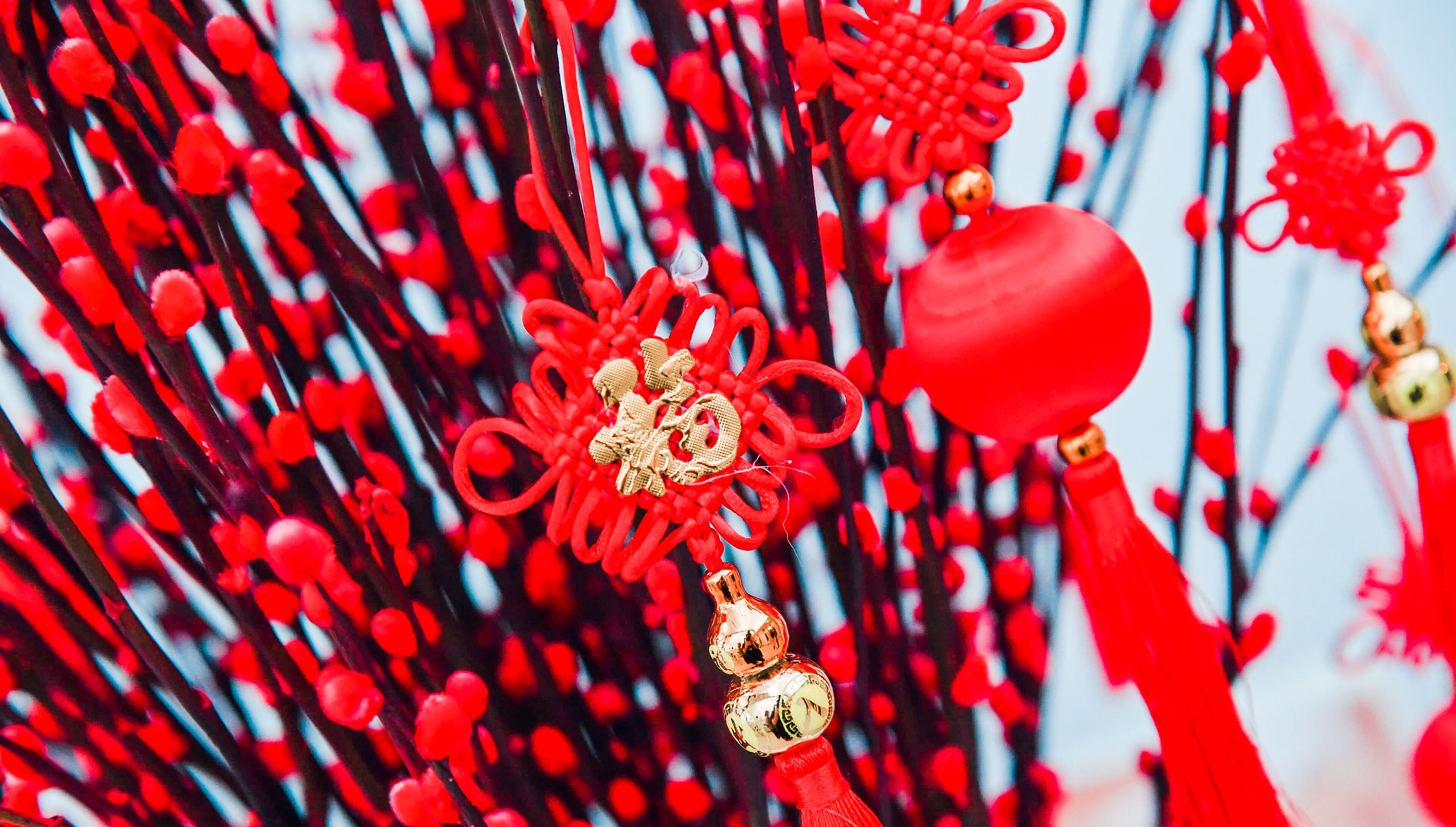 Un gros plan de décorations rouges et dorées, comprenant une sphère rouge et un motif floral doré.