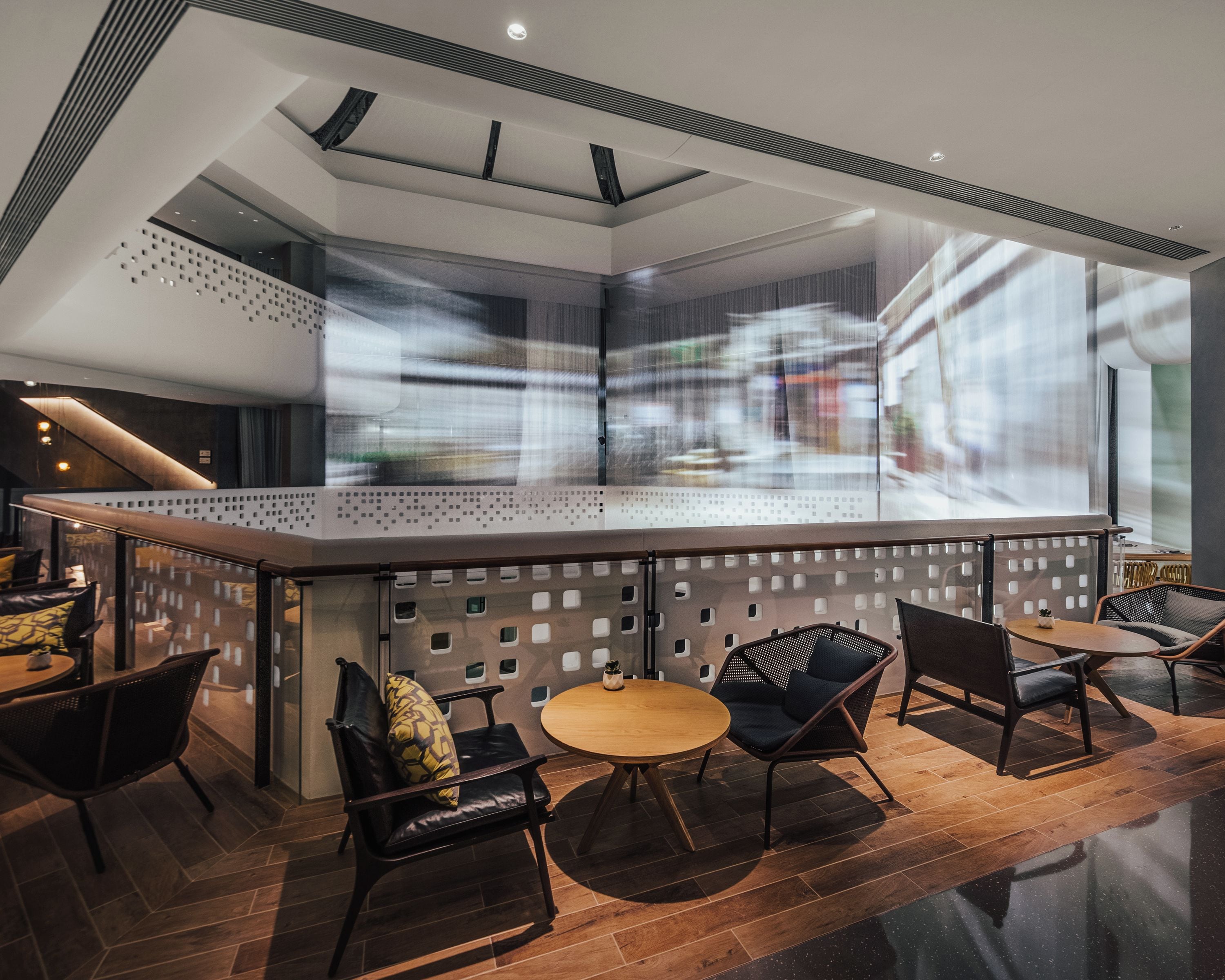 A modern interior with a central bar area, seating arrangements, and a view through a patterned partition.