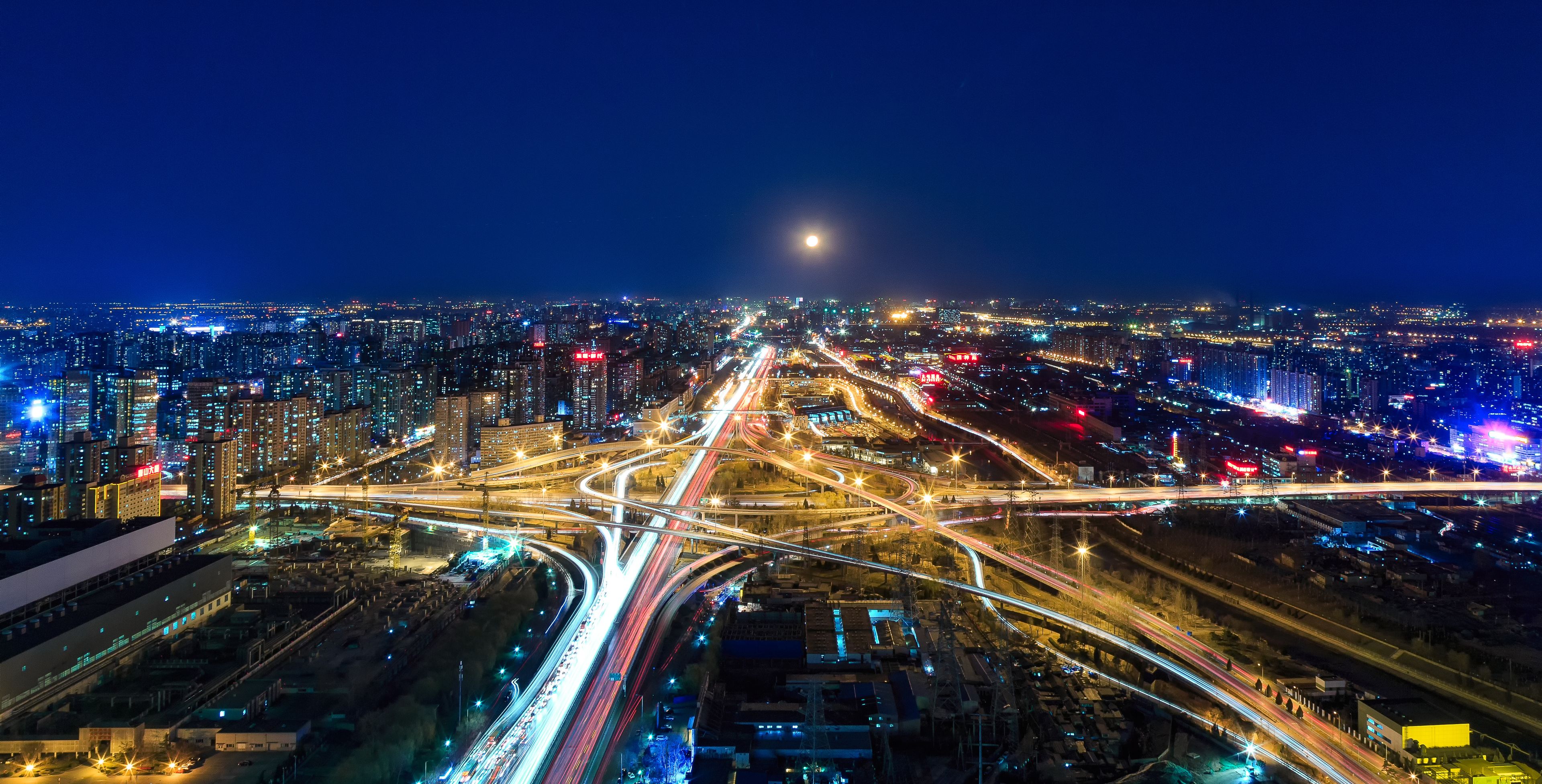 Un paisaje urbano nocturno con una intrincada red de autopistas y edificios iluminados.