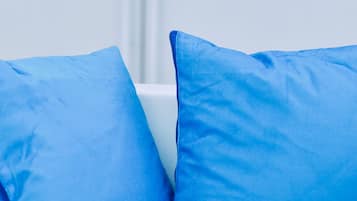 Primer plano de dos almohadas azules sobre fondo blanco.