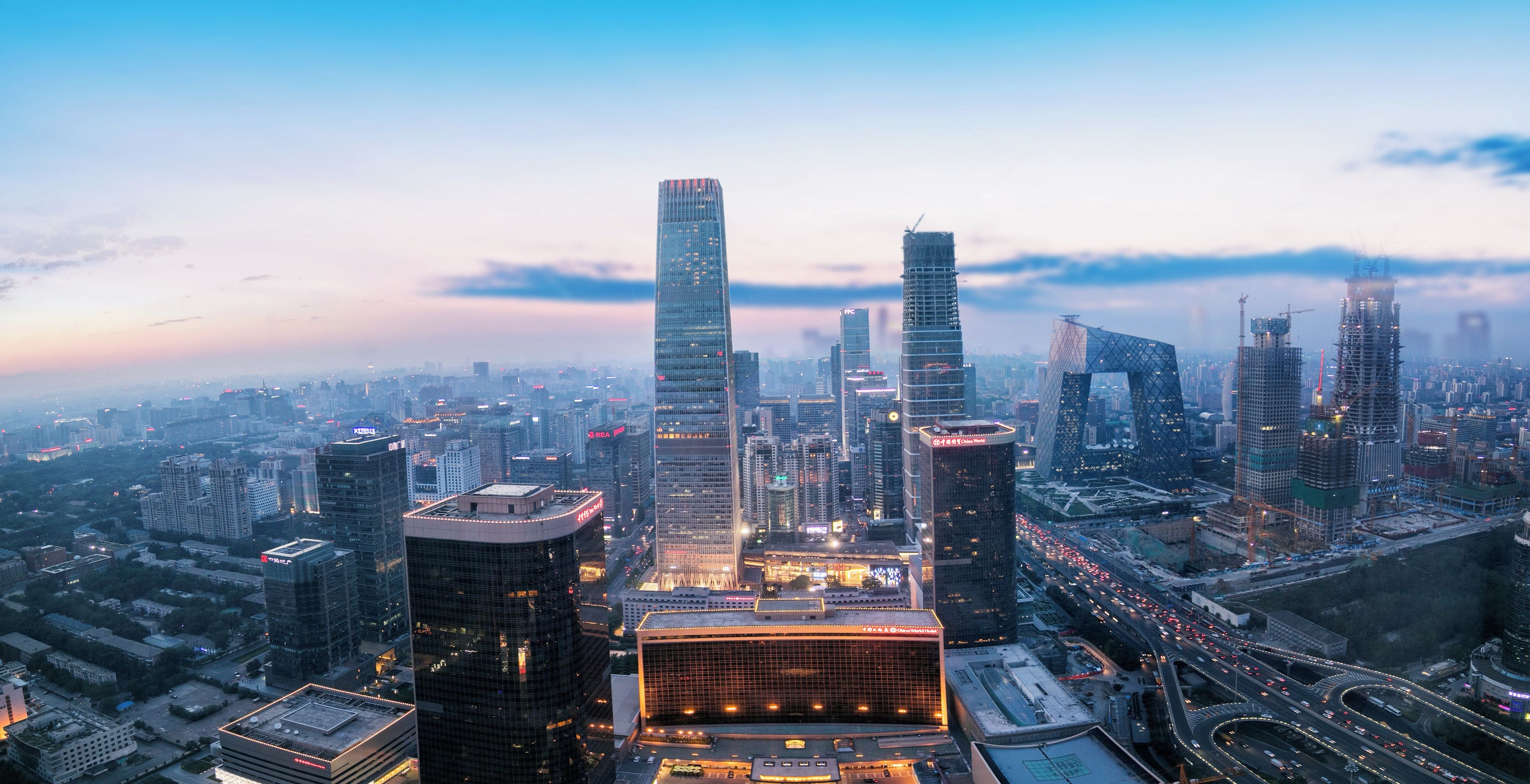 A cityscape with modern skyscrapers and a prominent building with a unique architectural design.