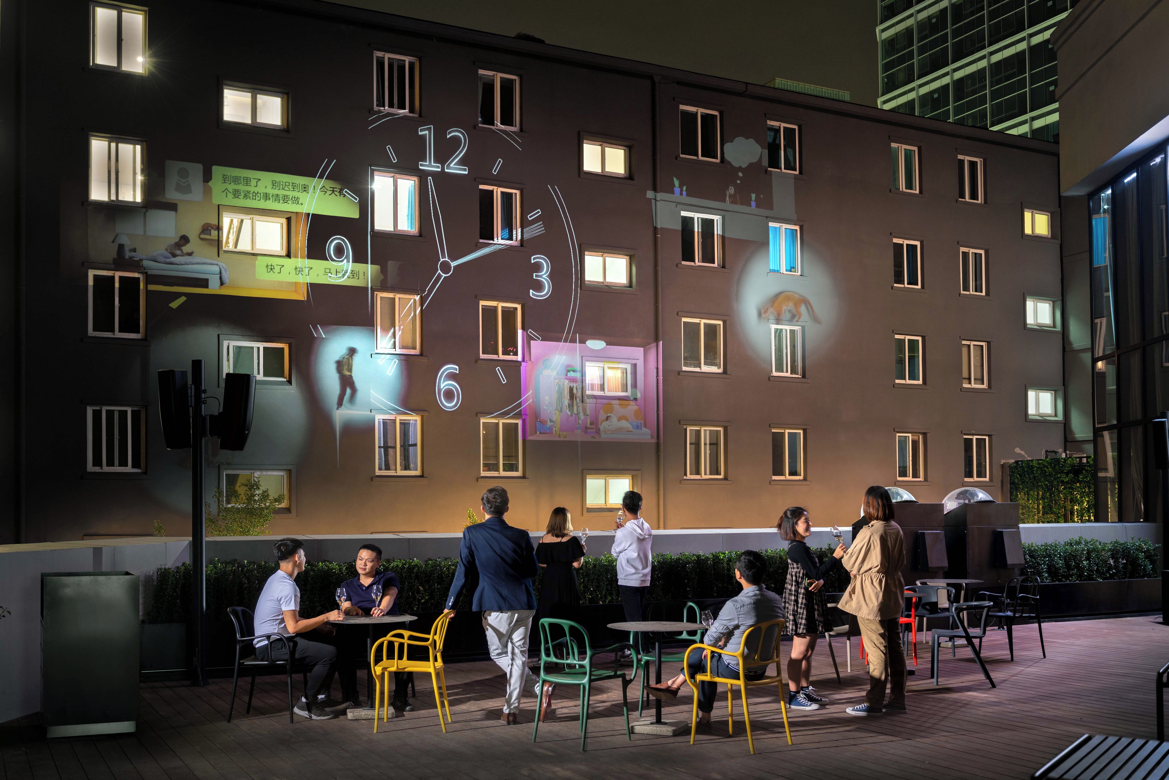 A building facade with a large illuminated clock and multiple windows.