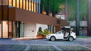 Un edificio moderno con un automóvil estacionado frente a él.