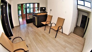 Un espacio habitable amplio con cocina, dos sillones y una chimenea.