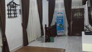 A room with a wooden floor, a bed, a TV, and a staircase.