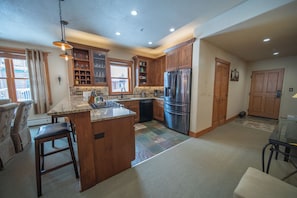 A spacious kitchen with wooden cabinets, a large island, and stainless steel appliances.
