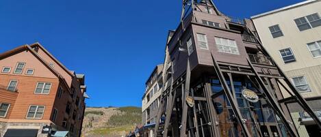 Un immeuble à étages doté d’une architecture originale, caractérisé par une tour imposante et de nombreuses fenêtres.
