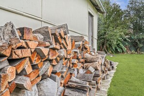 A stack of firewood against a building exterior.