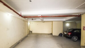 A parking garage with a black car parked in one of the spaces. -  Hotel Smart by Kelvish Hotel (New Delhi)