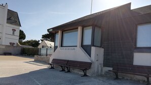 A building labeled "POSTE DE SECOURS" with a bench outside. - Studio with garden at the doors of the beach and thalasso ROSCOFF (Roscoff)