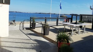 A seaside patio with a table and chairs, a bicycle, and potted plants. - Studio with garden at the doors of the beach and thalasso ROSCOFF (Roscoff)