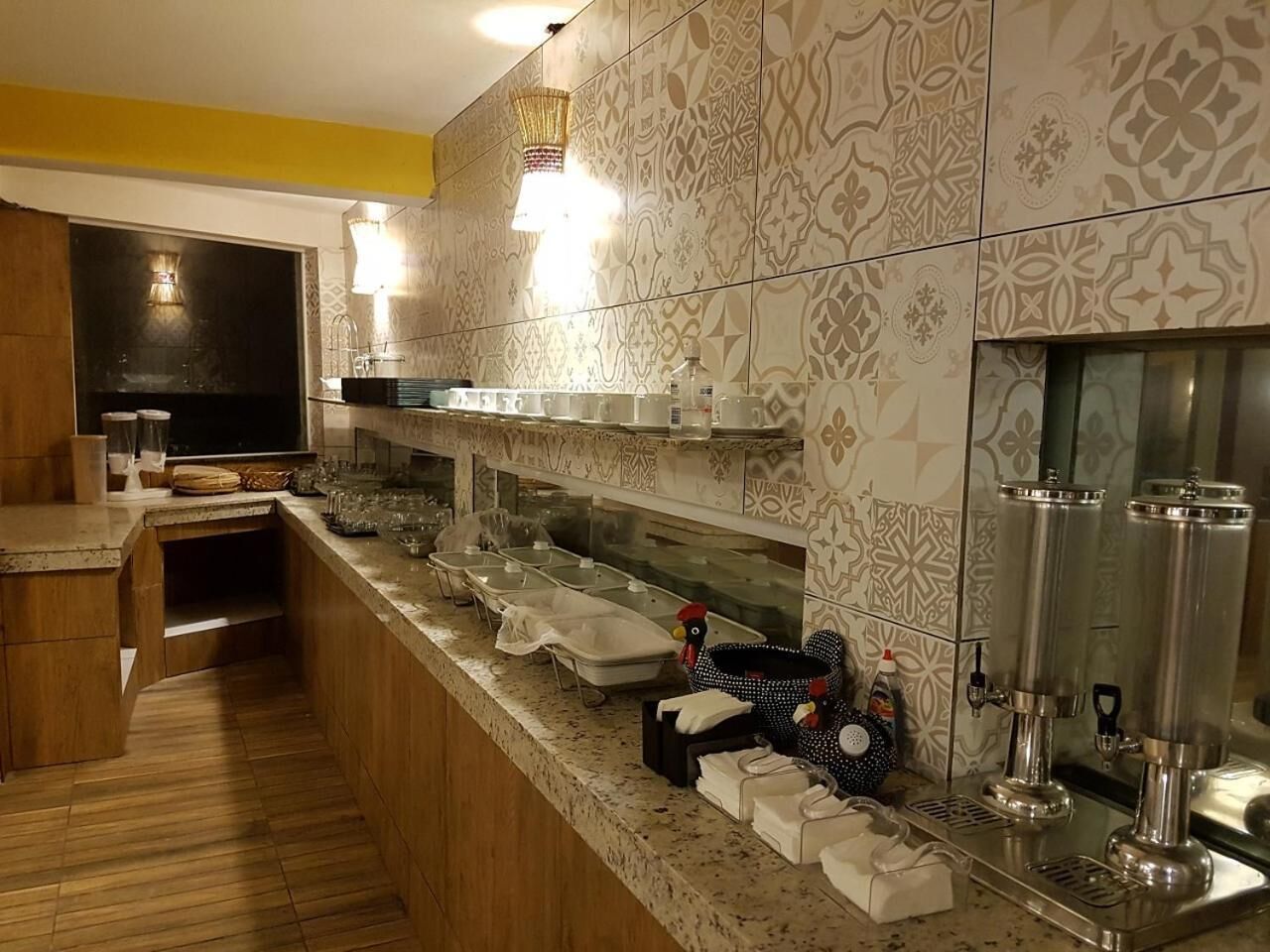 A modern kitchen with a wooden countertop, stainless steel appliances, and patterned tile backsplash.