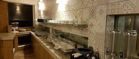 A modern kitchen with a wooden countertop, stainless steel appliances, and patterned tile backsplash.