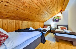 Cozy bedroom with two beds, a small table, and a unique wall decoration.