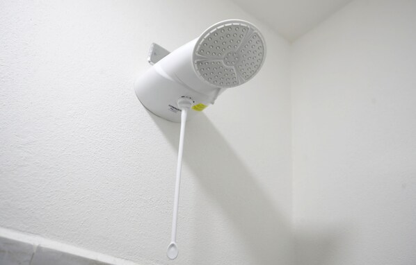 Un sèche-cheveux blanc, fixé au plafond, avec un cordon.