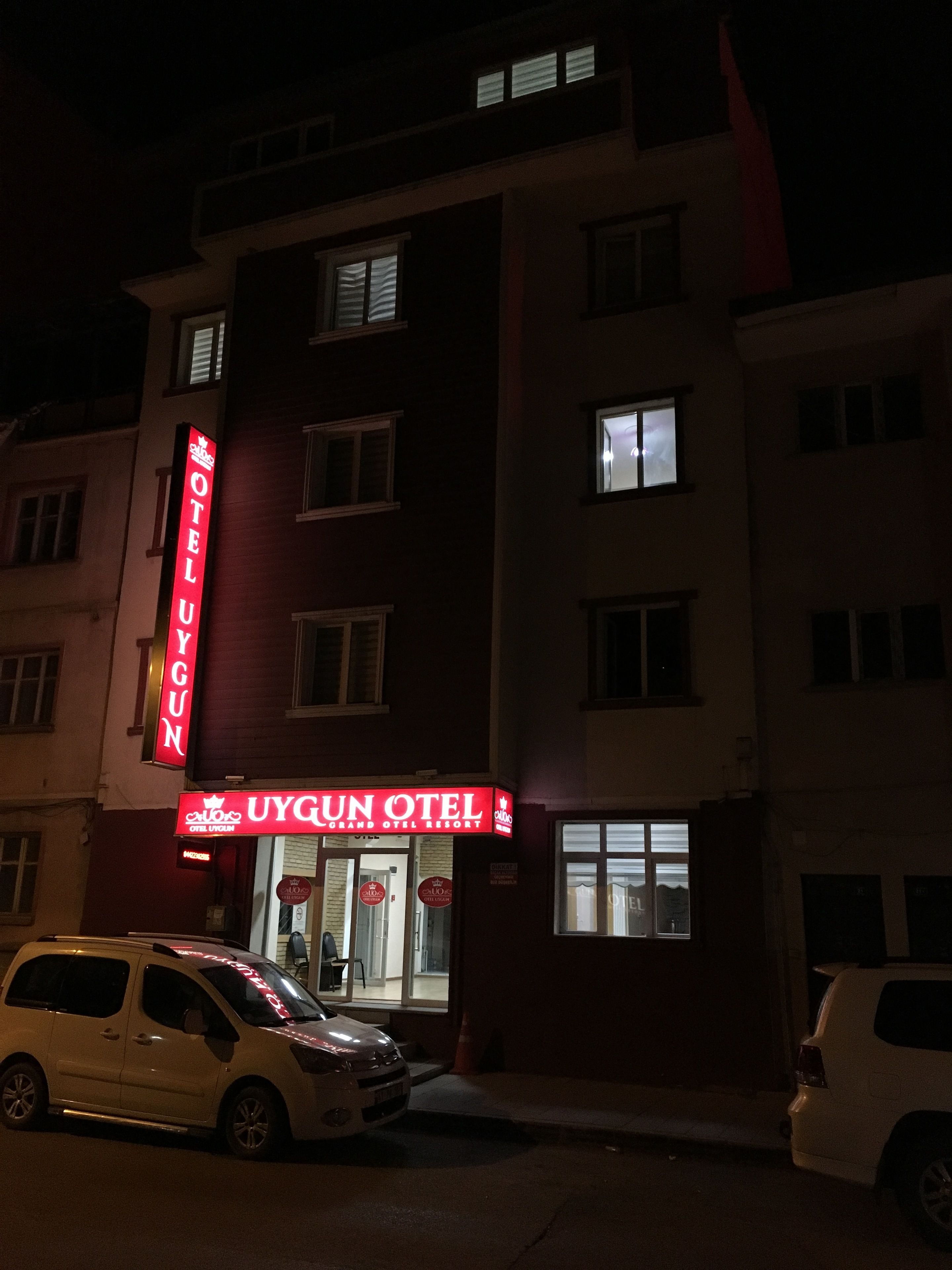 A multi-story building with a prominent red sign for UYGUN HOTEL.