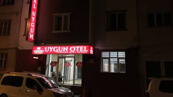 A multi-story building with a prominent red sign for UYGUN HOTEL.