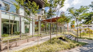 A modern building with glass facades, outdoor seating, and a staircase leading to the entrance. - Autenticco - Tita Salzano (São Paulo)