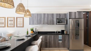 Una cocina moderna con encimera oscura, electrodomésticos de acero inoxidable y armarios de madera.