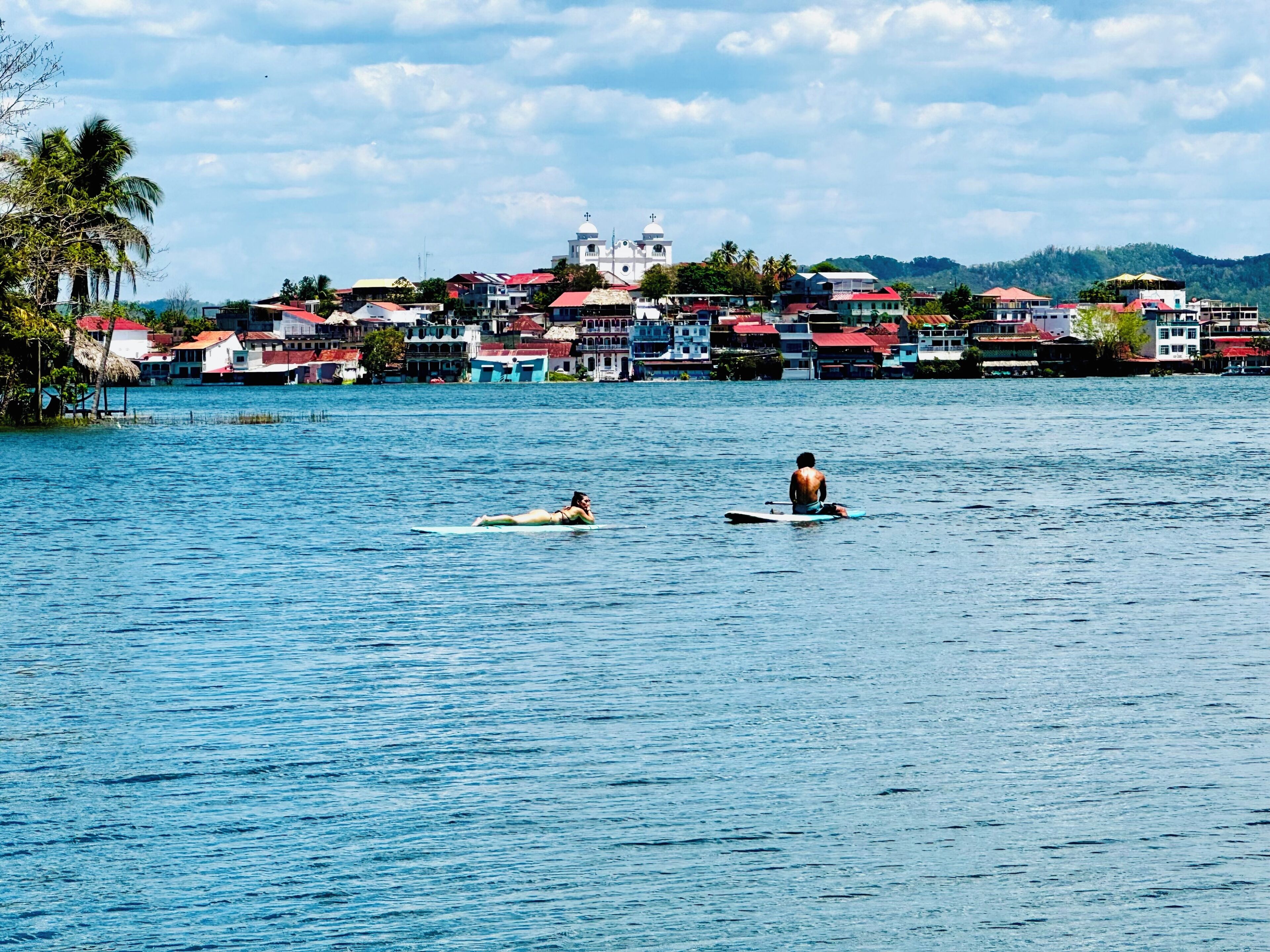 A coastal town with buildings, a church, and a calm sea.