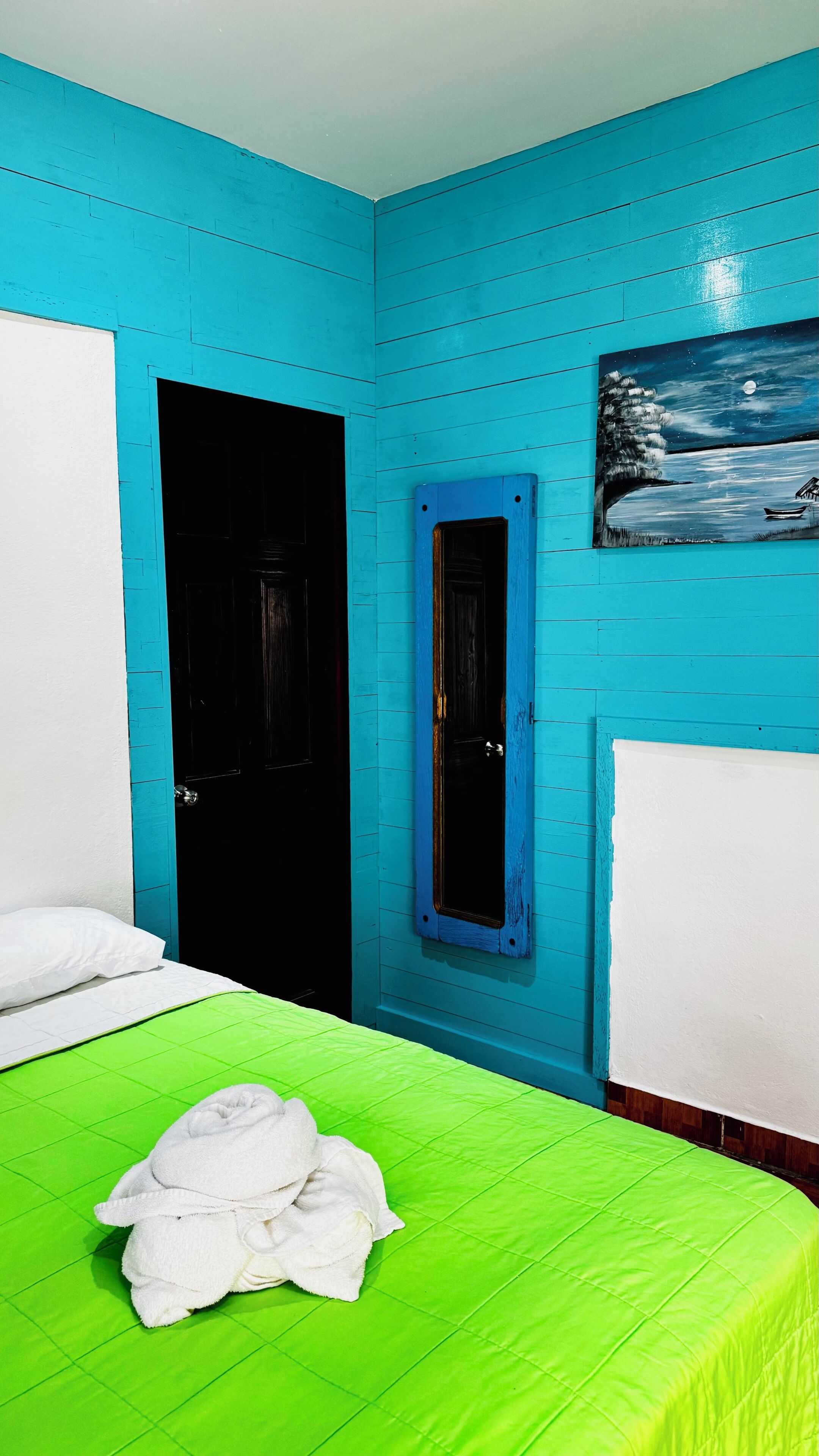 Una habitación con cama, ventana y puerta.