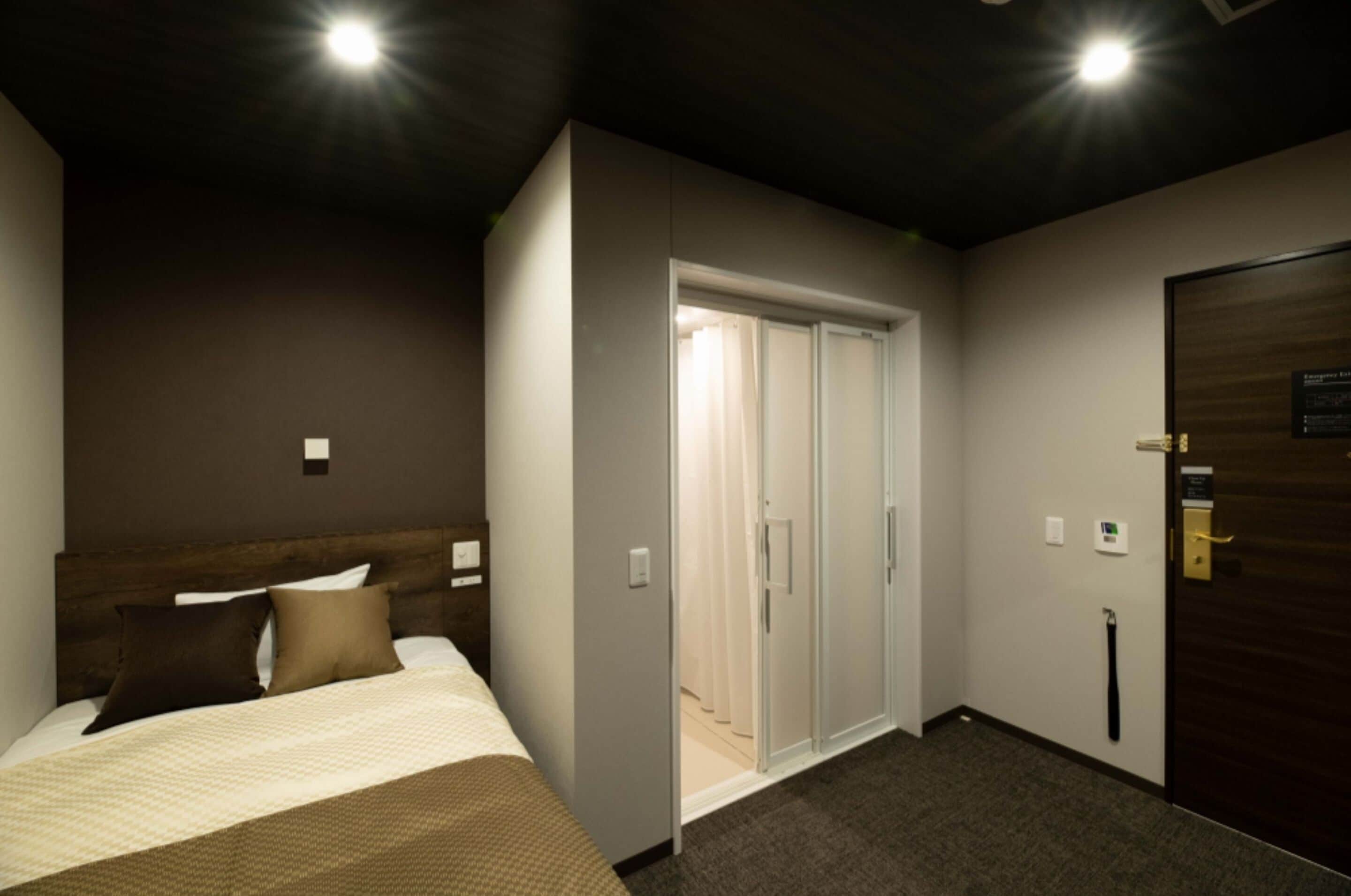 Une chambre d’hôtel avec un lit, une armoire et une porte.
