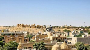 A cityscape with traditional architecture, including domed buildings and a hilltop structure with multiple domes.