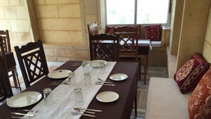 A dining area with a table set for four, including plates, glasses, and cutlery.