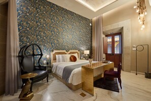 Une chambre d’hôtel avec un grand lit, un bureau, une chaise et un mur décoratif.
