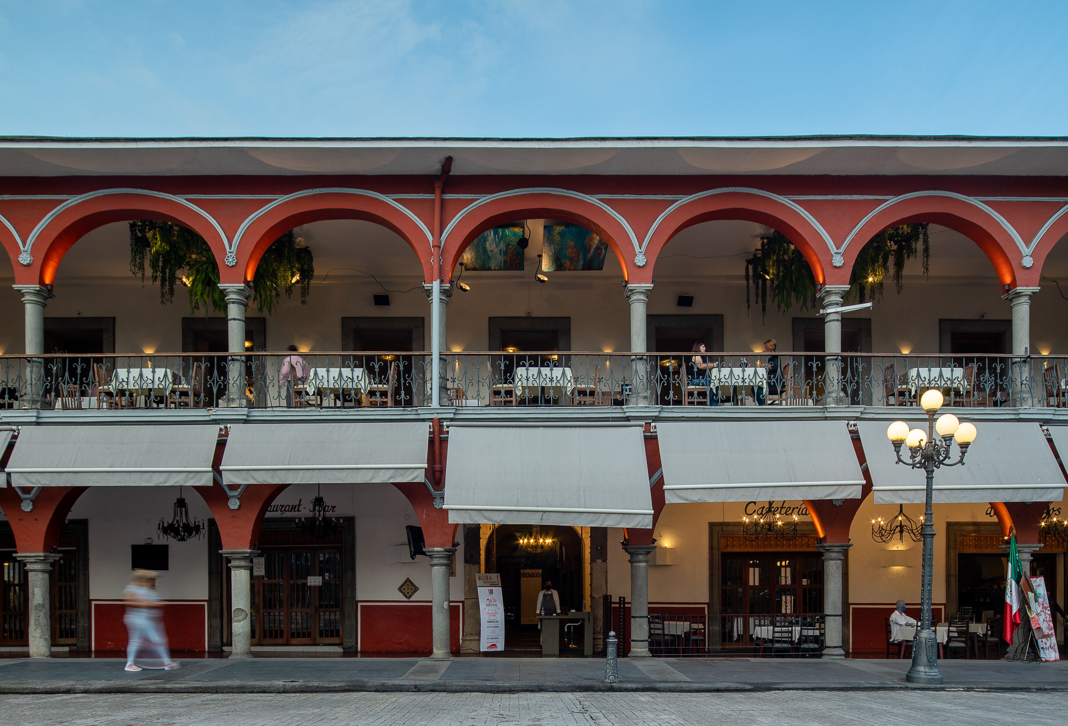 A building with multiple balconies, a cafe, and a restaurant.