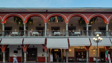 A building with multiple balconies, a cafe, and a restaurant.