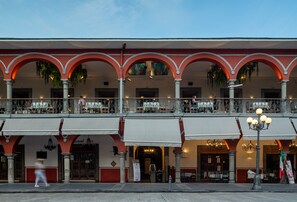 Un immeuble doté de nombreux balcons, d’un café et d’un restaurant.