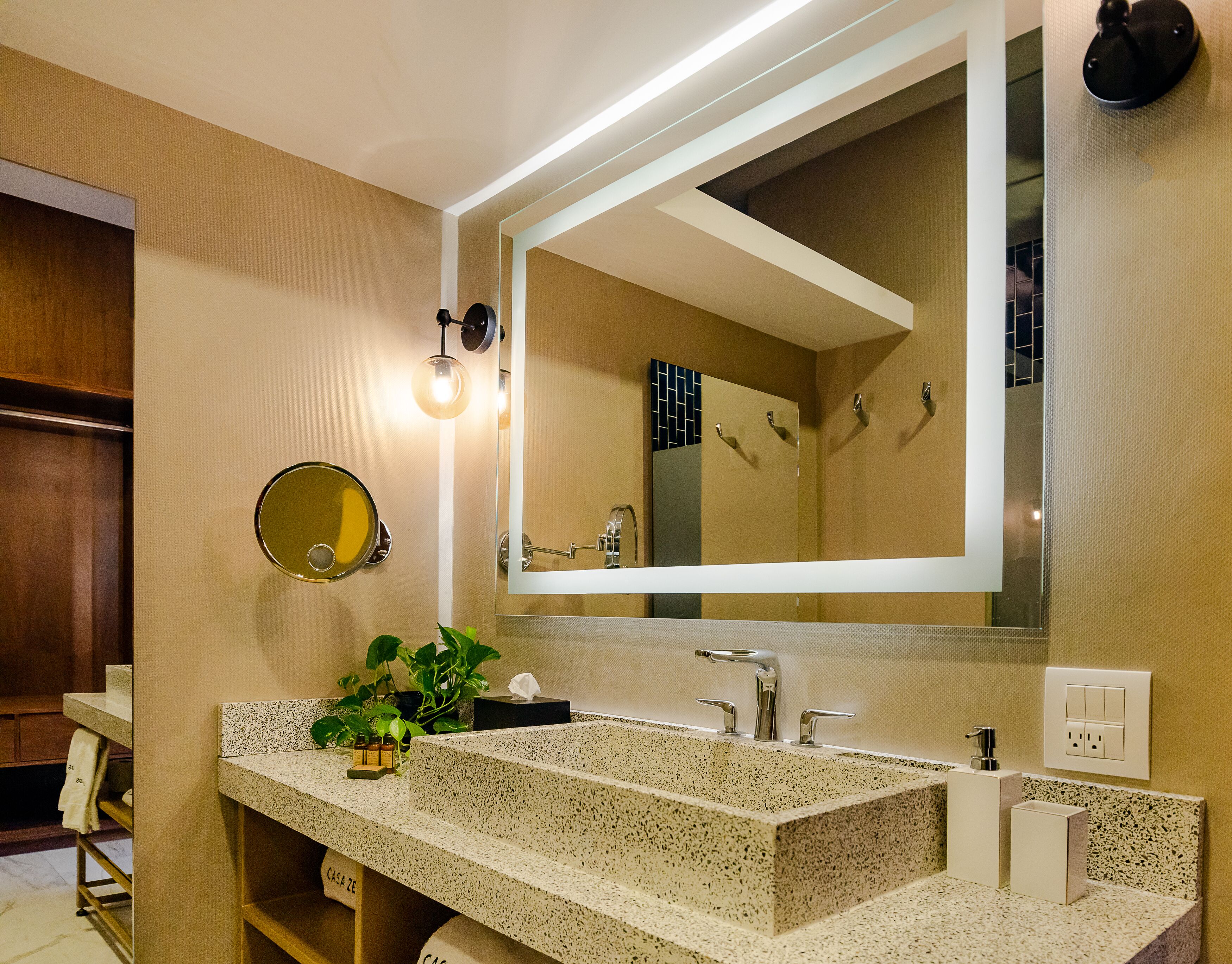 A bathroom with a granite countertop, a large mirror, and a towel rack.