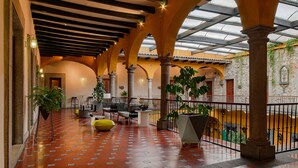 A spacious indoor area with a tiled floor, multiple seating arrangements, and a glass ceiling allowing natural light. - Hotel Boutique Casa Zevallos (Córdoba)