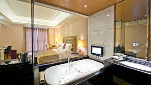 Un baño de hotel moderno con una bañera grande, un lavamanos independiente y un espejo amplio.
