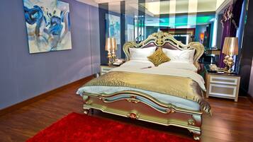 A luxurious bedroom with a classic four-poster bed, a red rug, and modern decor.