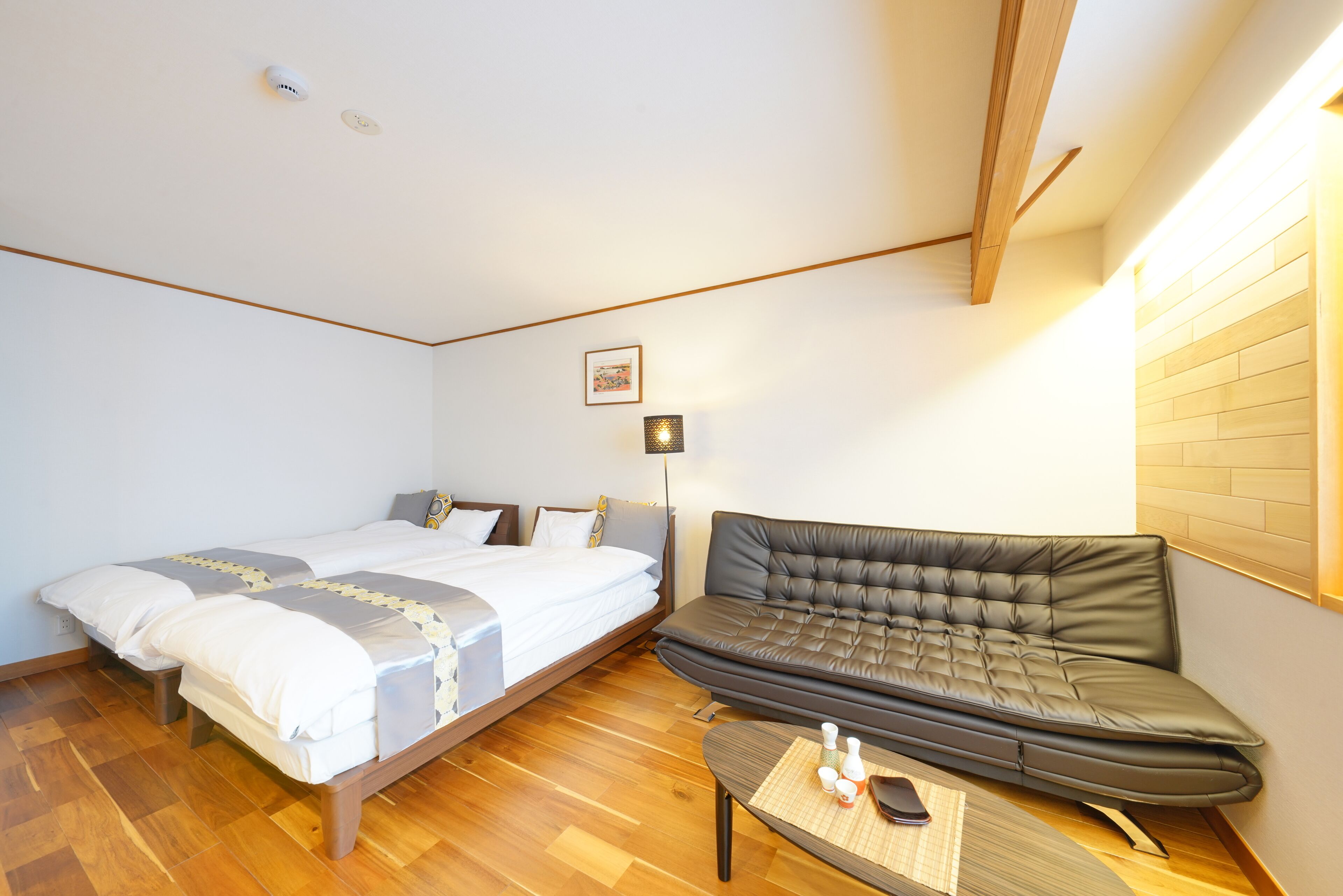 A bedroom with a bed, a sofa, and a small table with toiletries.