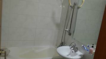 Un baño con bañera, lavamanos e inodoro.
